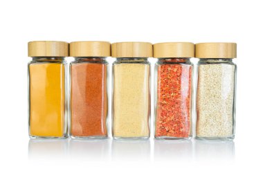 Beyaz kavanozlardaki farklı aromatik baharatlar.