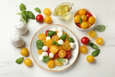 Taze salata, sarı domatesler, fesleğen ve mozzarella peyniri beyaz mermer masa, düz yatıyordu.