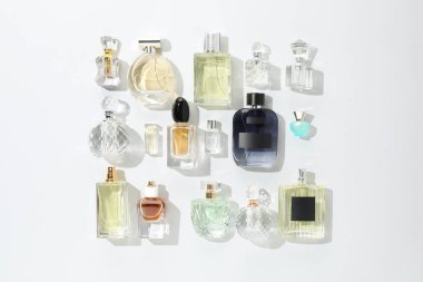 Hafif arka planda çeşitli parfüm şişeleri, düz yatıyordu.