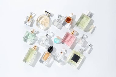 Hafif arka planda çeşitli parfüm şişeleri, düz yatıyordu.