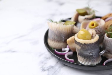 Hafif mermer masada zeytinli, turşulu, dereotlu ve soğanlı lezzetli ringa dürümleri, yakın plan. Metin için boşluk