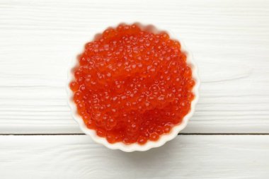 Lezzetli kırmızı havyar kasede beyaz ahşap masa, üst manzara