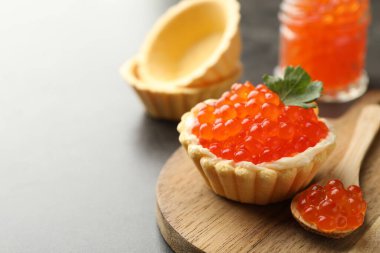 Kırmızı havyarlı kanepe, gri masada kaşık ve maydanoz, yakın plan. Metin için boşluk