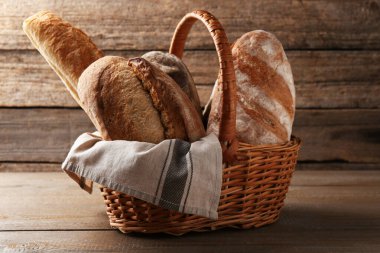 Tahta masadaki hasır sepette farklı somunlar.