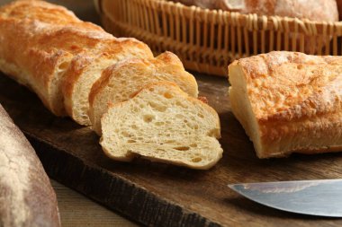 Tahta masadaki farklı taze ekmek türleri, yakın çekim.