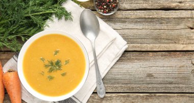 Ahşap masada servis edilen dereotlu mercimek kremalı leziz çorba. Metin için boşluk