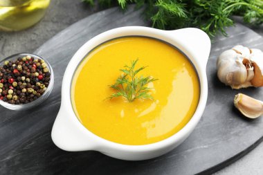 Gri masadaki dereotlu lezzetli mercimek kremalı çorba, yakın plan.