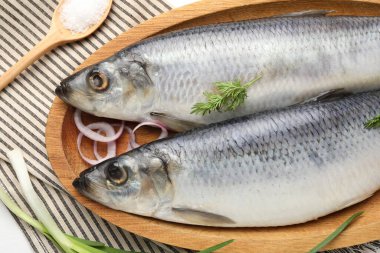 Tuzlu ringa balıkları ve baharatlar masada, düz yerde.