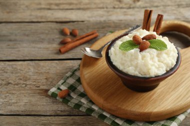 Tahta masada servis edilen bademli, nane ve tarçınlı lezzetli sütlaç, yakın plan.