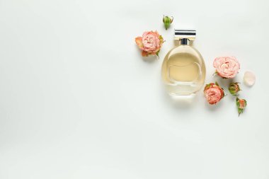 Bir şişe aromatik parfüm ve beyaz arka planda güzel çiçekler. Metin için boşluk