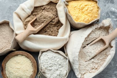 Gri desenli sehpada, düz yerde duran farklı tipte un var.