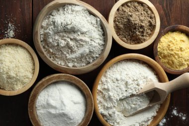 Tahta masadaki kaselerdeki farklı un türleri, düz uzanmış.