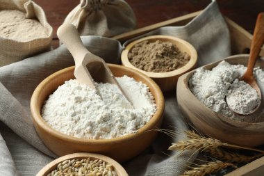 Tahta masadaki kaselerdeki farklı un türleri, yakın plan.