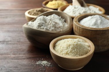 Tahta masadaki kaselerdeki farklı un türleri, yakın plan.