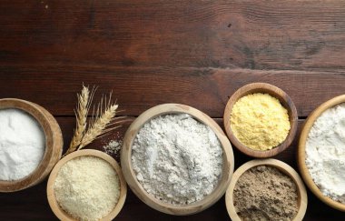 Tahta masadaki kaselerdeki farklı un türleri, düz yatış. Metin için boşluk