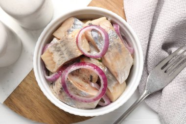 Beyaz masadaki soğanlı lezzetli ringa balıkları.