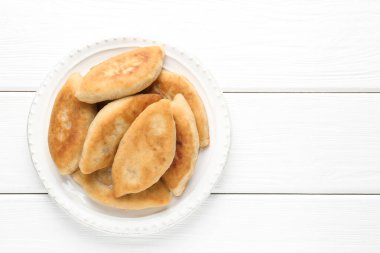 Beyaz ahşap masa üzerinde nefis kızarmış pirizky (doldurulmuş turtalar), üst manzara. Metin için boşluk