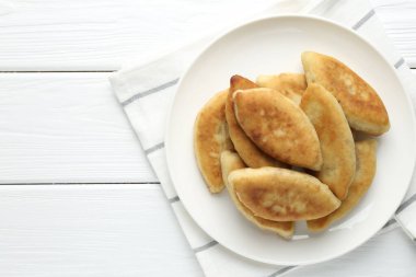 Beyaz ahşap masa üzerinde nefis kızarmış pirizky (doldurulmuş turtalar), üst manzara. Metin için boşluk