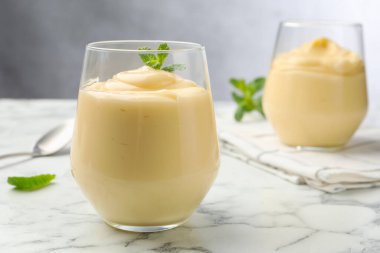 Beyaz mermer masada naneli vanilyalı puding, yakın plan.