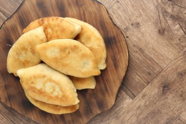 Ahşap masada nefis kızarmış pirizky (doldurulmuş turtalar), üst manzara. Metin için boşluk