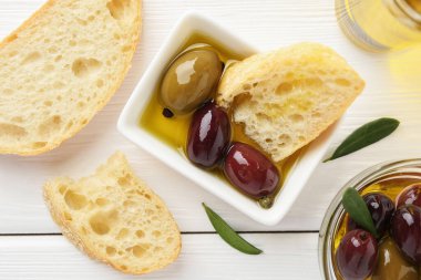 Beyaz ahşap masa üzerinde yağlı ve zeytinli dilimler, düz yatıyordu.