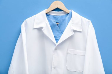 Doktorun ceketi mavi arka planda asılı.