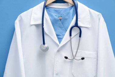 Doktorun ceketi mavi arka planda, yakın plan.