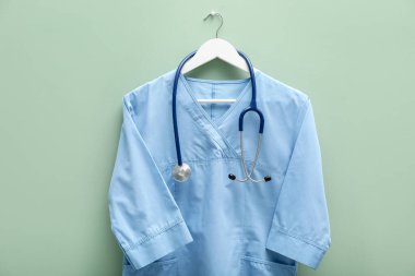 Açık mavi arka planda steteskoplu sağlık çalışanı üniforması.