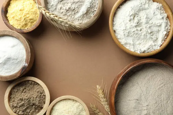 Açık kahverengi masadaki farklı tipte undan yapılmış çerçeve düz. Metin için boşluk