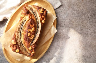 Ev yapımı muz ekmeği, fındıklı gri masa, üst manzara. Metin için boşluk