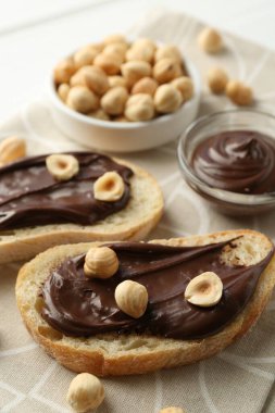 Çikolatalı ekmek dilimleri ve masada fındıklar, yakın plan.
