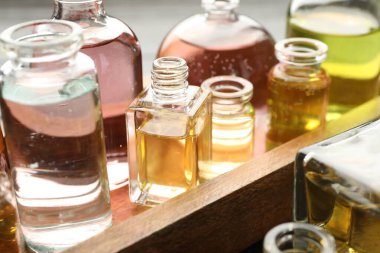 Arka planda aromatik yağlı parfüm şişeleri, yakın plan.