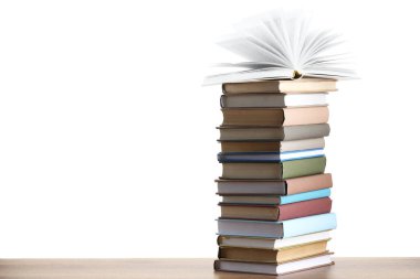 Beyaz arkaplana karşı ahşap masadaki eski kitaplar yığını