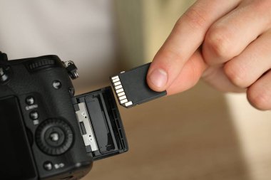 SD bellek kartını fotoğraf makinesine yerleştiren adam, kapat
