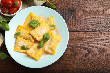 Tahta masada servis edilen peynirli ve fesleğenli lezzetli ravioli. Metin için boşluk