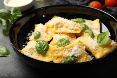 Siyah masada parmesan peynirli ve fesleğenli lezzetli ravioli, yakın plan.