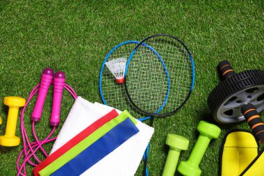 Yapay yeşil çimlerde farklı spor aletleri, düz yatış.