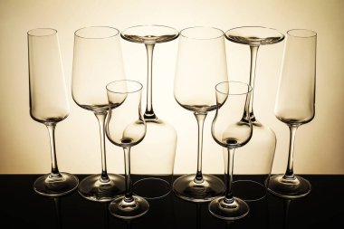 Ayna yüzeyinde bej arkaplana karşı birçok boş temiz bardak