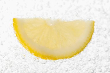 Soda water with lemon slice as background, closeup