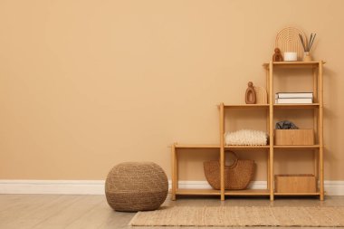 Dekor ve pouf ile raf ünitesi kapalı alanda bej duvar, metin için boşluk