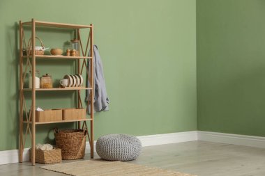 İçerideki zeytin duvarının yanında farklı dekorasyonu olan ahşap raf ünitesi. Metin için boşluk