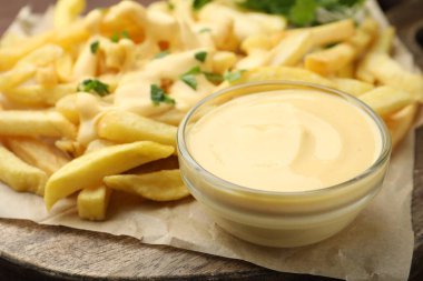 Tabakta leziz peynir sosu, masada patates kızartması ve maydanoz, yakın plan.