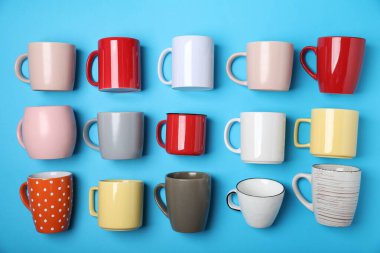 Açık mavi arkaplanda bir sürü renkli fincan, düz yatıyordu.