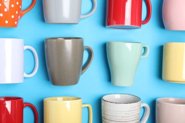 Açık mavi arkaplanda bir sürü renkli fincan, düz yatıyordu.