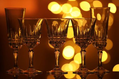 Bulanık ışıklara karşı cam ayna yüzeyinde birçok temiz bardak var. Bokeh etkisi