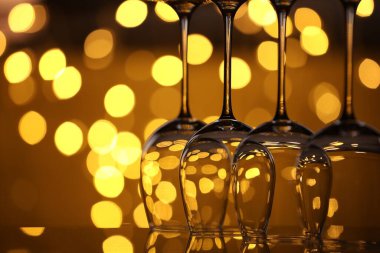 Bulanık ışıklara karşı cam ayna yüzeyinde birçok temiz bardak, yakın plan. Bokeh etkisi