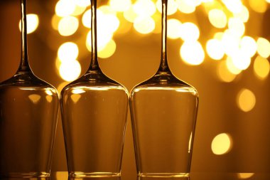 Bulanık ışıklara karşı birçok temiz bardak, yakın plan. Bokeh etkisi