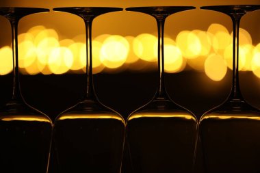 Bulanık ışıklara karşı birçok temiz bardak, yakın plan. Bokeh etkisi