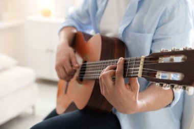 Evde gitar çalan adam, eline odaklan.