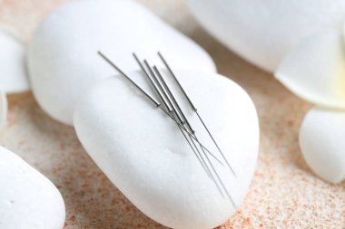 Akupunktur iğneleri ve spa taşları ışık desenli masa, yakın çekim